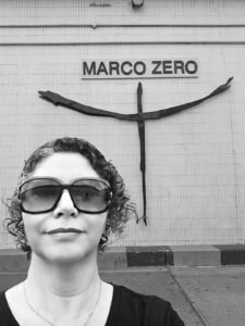 Fotografia de Janei Cristina, preto e branco, em frente ao marco zero em Brasília, Distrito Federal